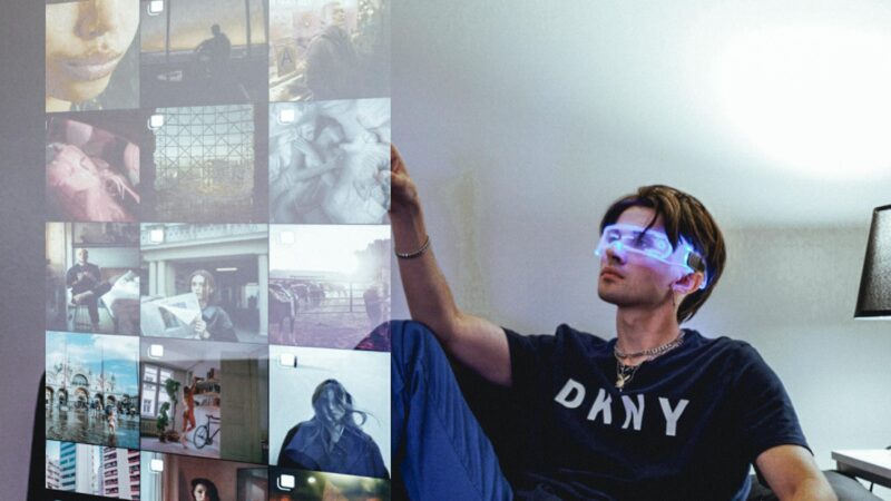 a man sitting on a couch touching a large screen